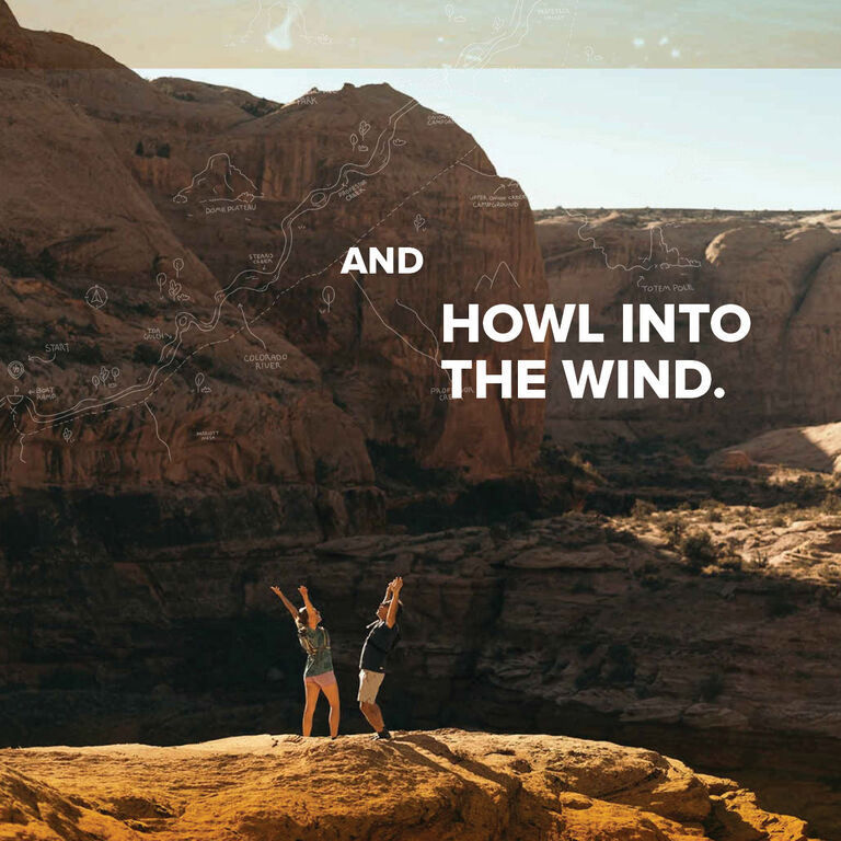 A man and a woman trekking through mountains wearing Teva hiking boots.