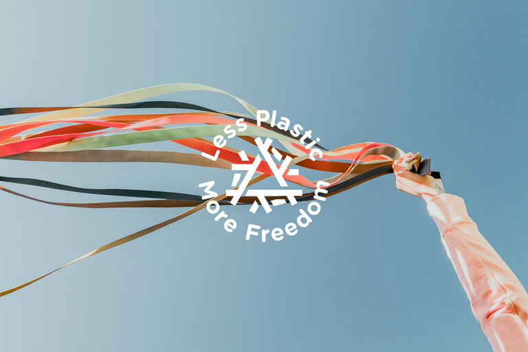 Teva's Sandal straps held by women a blue sky background. Text reads 'less plastic more freedom'